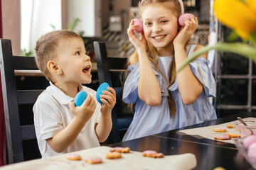 Little boy and girl are preparing for Easter, having fun and playing. Easter eggs. Happy Easter.