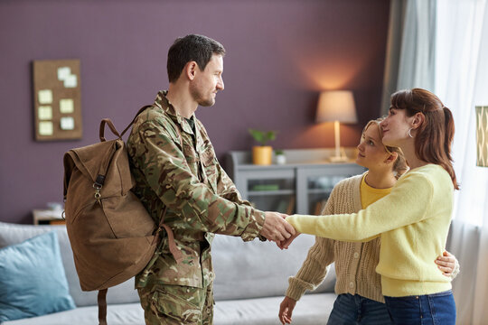 Side view portrait of military man with family welcoming home