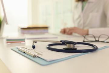 Stethoscope and medical records on doctor table in hospital