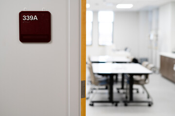 Medical Lifestyle Image. Nurse and Doctor. Medical Student in Training. Classroom indicator with visible table and chairs inside room. 