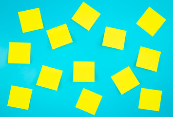 Blank yellow sticky notes on a blue background, flat lay. Space for text. Time management, priorities, efficiency, control and goals concept.