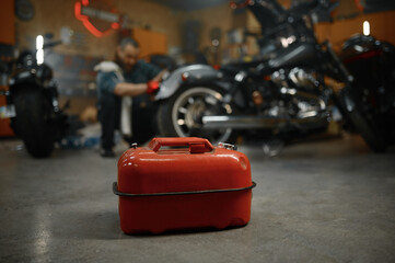 Selective focus on fuel canister in motorcycle garage