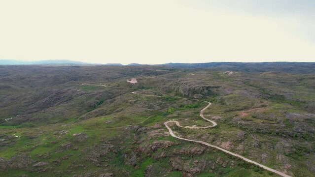 Camino, carretera, de ripio en pradera monta&ntilde;osa un d&iacute;a soleado, visto desde un dron. C&oacute;rdoba, Argentina, Latinoam&eacute;rica