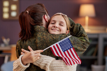 Portrait of happy girl embracing mother coming home from military service