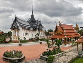 Fototapeta premium Panoramic photo of the architectural park of Oriental culture. Religious buildings of Thai history: palace and temple complexes. The exhibits are surrounded by ponds, tropical greenery and flowers