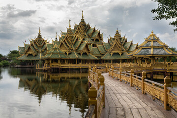 Fototapeta na wymiar Panoramic photo of the architectural park of Oriental culture. Religious buildings of Thai history: palace and temple complexes. The exhibits are surrounded by ponds, tropical greenery and flowers