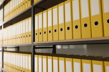 Yellow folders with materials put in long rows on shelves