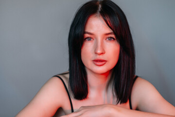 Naklejka premium A large portrait of a brunette illuminated by a red lamp 4570.