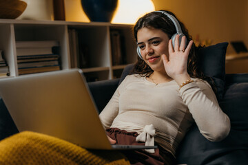 A young Caucasian woman is having an online meeting at home