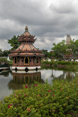 Fototapeta na wymiar Architectural park of Oriental culture. Religious buildings of Thai history: palace and temple complexes. The exhibits are surrounded by ponds, tropical greenery and flowers
