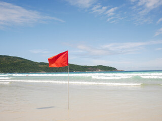Red flag on a tropical island beach