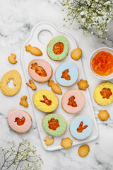Easter linzer cookies with apricot jam and colorful powdered sugar. Egg shaped almond biscuits.  Top view