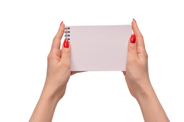 A notebook with empty white paper in woman hands with red nails.