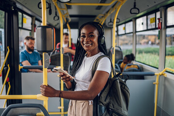 African american woman riding in a bus and using a smartphone