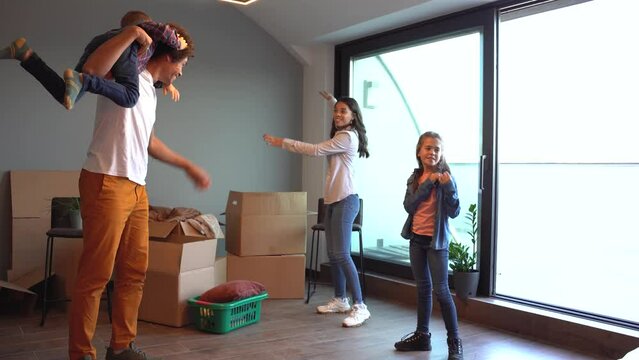 Mixed race family moving into their new home. They're unpacking and having fun together.	
