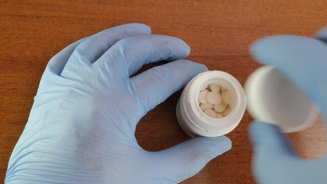Tablets of potassium iodide are poured onto the hand. Radiation danger. Danger of overdose. View from above.