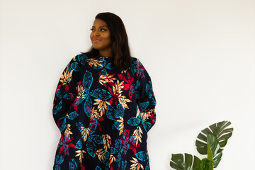 Portrait of african american woman smiling against white wall in room - inclusion and diversity concept. copy space and empty space for text or advertising