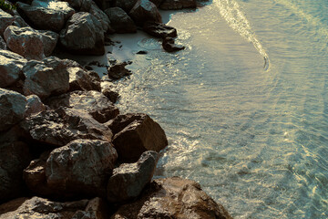 big rocks on sea or ocean sandy coast, calm water, tide