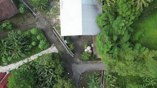 Aerial footage of a self-help waste processing site in the sub-district, slow-motion drone footage of a building used as a collection site for household & small-scale industrial waste
