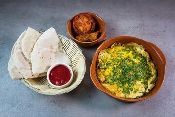 Spanish Omelet with bread, fried tomato and sauce served in dish isolated on grey background top view of bahrain food