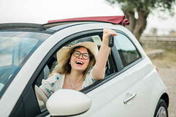 Fototapeta na wymiar Young happy woman showing key of new car - Rental and buy new car concept