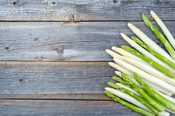 Frischer roher weißer und grüner Spargel angeboten als Draufsicht auf einem rustikalen...