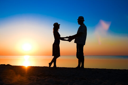 A Happy couple by the sea at sunset on travel silhouette in nature