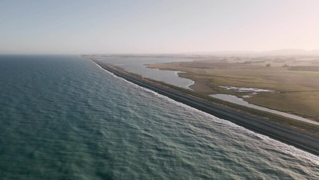Gorgeous aerial footage of Waimate Beach in Canterbury, NZ during a glowing orange sunset