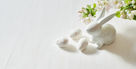 Holiday composition with spring flowers and easter eggs, white bunny on a light background. Happy easter concept with copy space