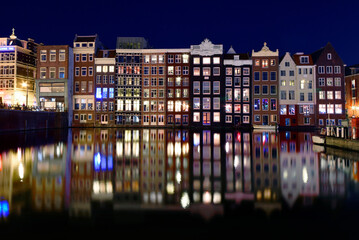 Fototapeta na wymiar Amsterdam dancing houses. Colours and reflections at night