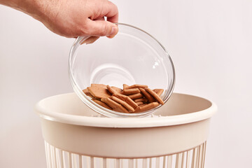 Expired, stale crackers are thrown into the trash. Disposal and recycling of food products.