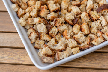 Crispy cubes of bread, croutons of white bread for cream soups. crackers on a white plate of wheat bread with olive oil and garlic. Recycling zero waste concept