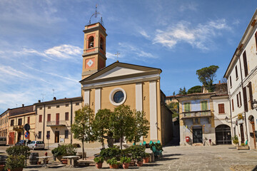 Predappio Alta, Forli Cesena, Emilia Romagna, Italy: the main square Piazza Cavour with the church and the Post office building in the old town of the ancient Italian village - 585932655