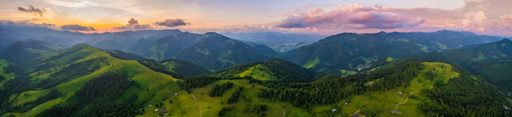 Amazing morning fog in the mountains. Beautiful sunrise light shines on the red beech forest. Drone panorama.