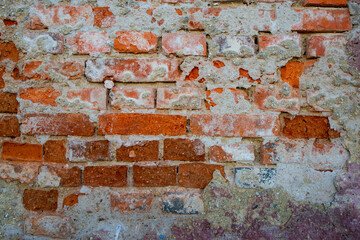 Texture of old brick wall with collapsed plaster