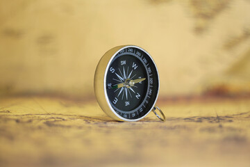 Classic round compass on background of old vintage map