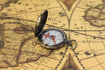 Classic round compass on background of old vintage map
