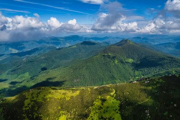 Obraz premium Aerial view of beautiful mountain forest covered with fluffy clouds.