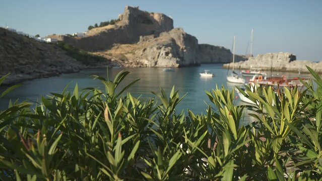 Sailboats on the water, Lindos and Lindos Acropolis from Paralia Agios Pavlos Beach, Lindos, Rhodes, Dodecanese Islands, Greek Islands, Greece, Europe