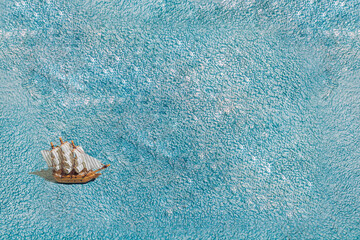 A wooden ship on a blue towel. Minimal.
