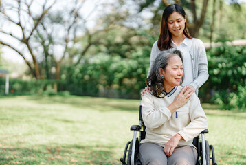 Fototapeta na wymiar Family relationship, Asian senior woman in wheelchair with cheerful daughter spending time together