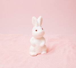 White Easter bunny on a pink background. Minimal design.