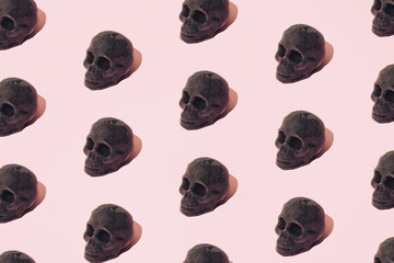 A wax skeleton head on a pink background. Pattern.