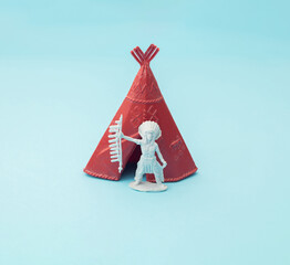 Indian chief standing next to a red tent. Blue background. Minimal design.