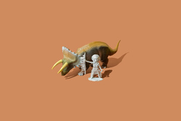 Native Indian American chief leader standing next to a large triceratops dinosaur beast on a brown background.