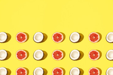 Fototapeta premium Arranged half coconut and grapefruit on a pastel background. Background yellow color.