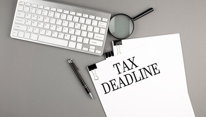 TAX DEADLINE text on paper with keyboard on grey background