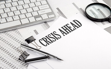 CRISIS AHEAD text on paper with chart and keyboard, business concept