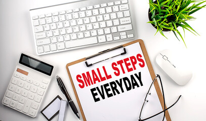 Business concept.Text SMALL STEPS EVERYDAY on paper clipboard with,pencil,glasses, keyboard and calculator on white background.