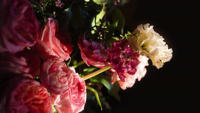 Bouquet of Pink Roses and Leaves Against Black Background